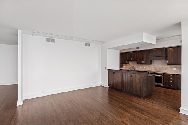 1040 N Lake Shore Dr Unit 34C, Chicago, IL 60611 - kitchen with dark wood-style flooring, dark brown cabinetry, stainless steel oven, backsplash, and a peninsula