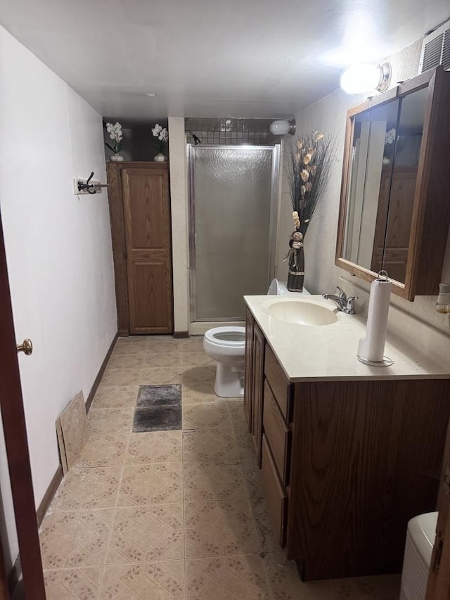 bathroom with vanity, toilet, and a shower with shower door