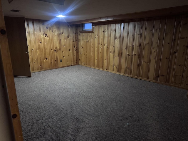 basement with carpet and wood walls