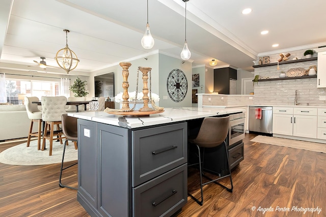 kitchen with a kitchen bar, dishwasher, white cabinets, and decorative backsplash