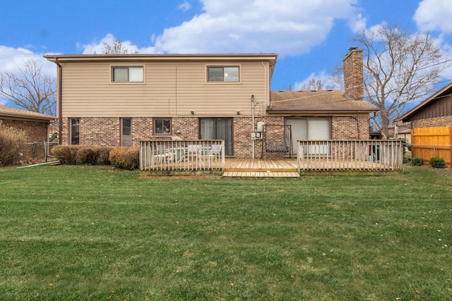 rear view of house with a deck and a lawn