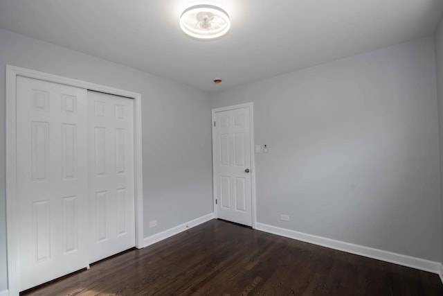 unfurnished bedroom with a closet and dark hardwood / wood-style floors