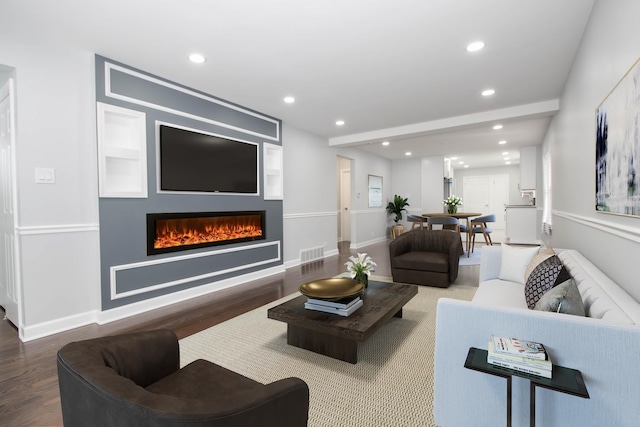 living room featuring hardwood / wood-style flooring and built in shelves