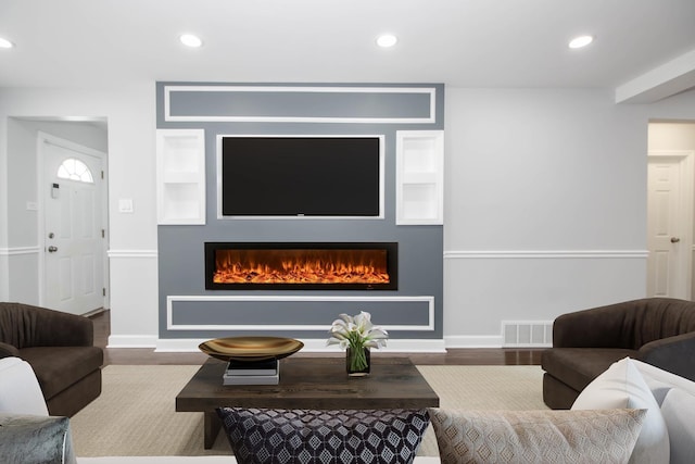 living room with hardwood / wood-style floors and built in shelves