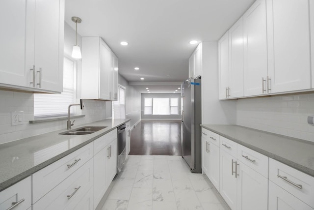 kitchen featuring white cabinets, hanging light fixtures, and appliances with stainless steel finishes