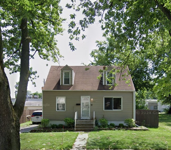 cape cod home featuring a front lawn