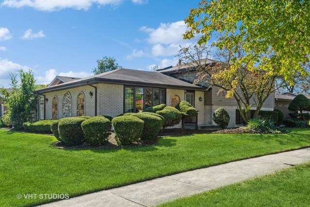 split level home featuring brick siding, a chimney, and an attached garage