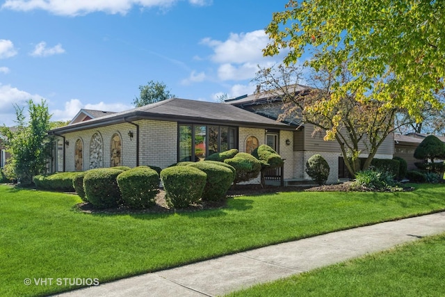 view of front of home featuring a front yard and brick siding