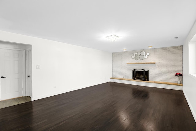 unfurnished living room with a brick fireplace and hardwood / wood-style floors