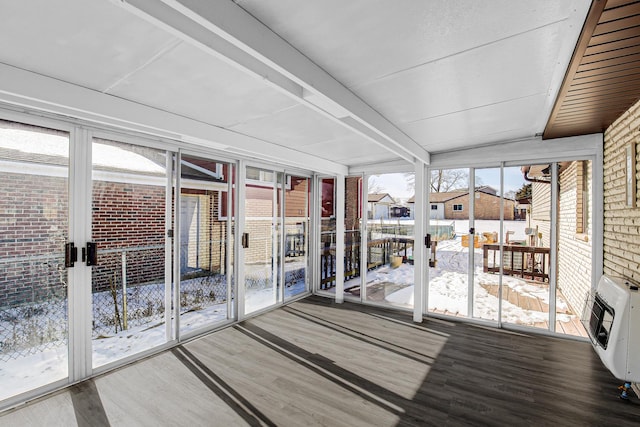 unfurnished sunroom featuring heating unit and beam ceiling