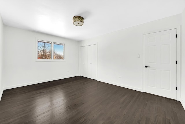 unfurnished bedroom featuring a closet and dark hardwood / wood-style flooring