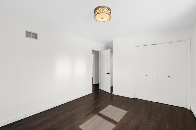 unfurnished bedroom featuring dark hardwood / wood-style floors and a closet