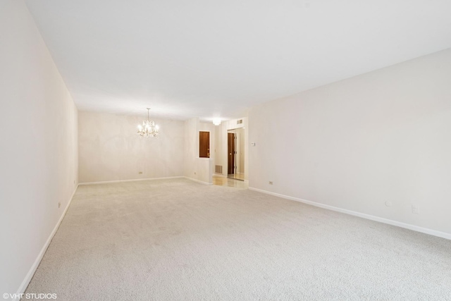 unfurnished room with baseboards, light colored carpet, and a notable chandelier