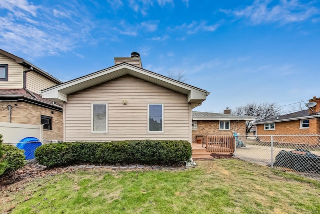 rear view of property featuring a lawn and a deck