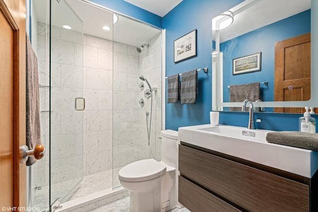 bathroom featuring vanity, toilet, and a shower with door