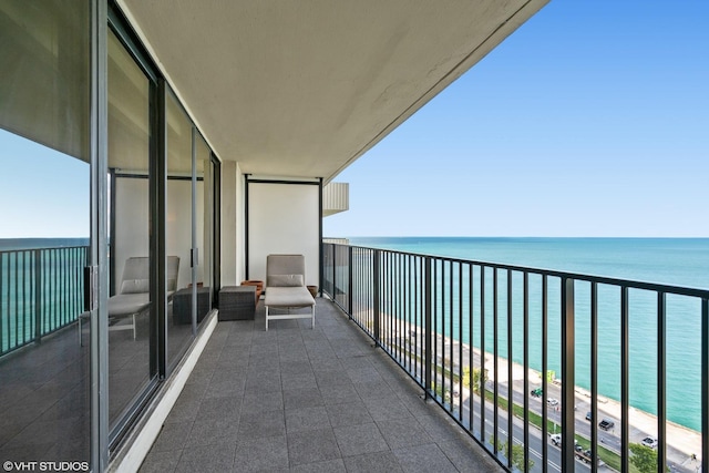 balcony with a water view and a view of the beach