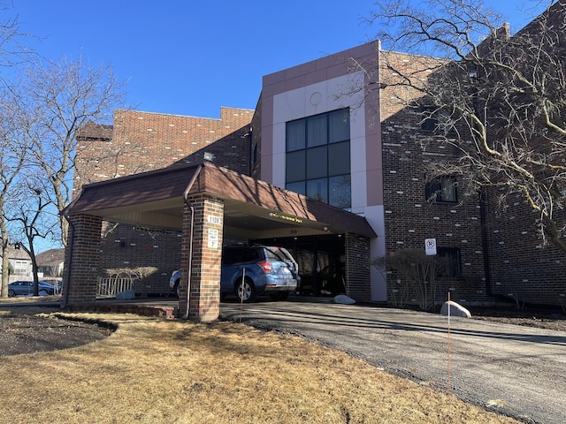 exterior space featuring driveway and brick siding