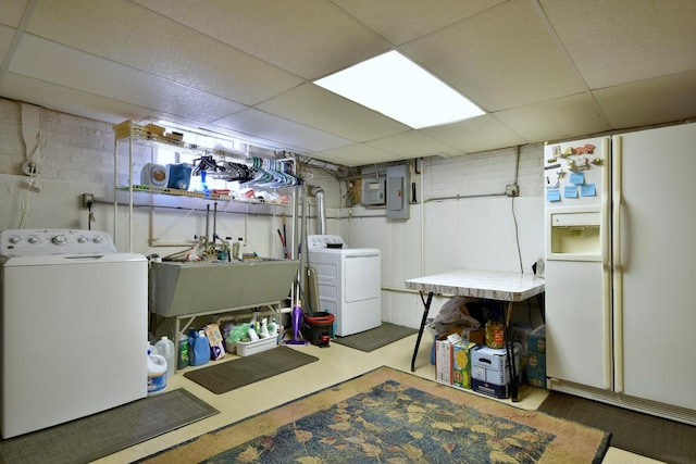 laundry room featuring laundry area, electric panel, washer and clothes dryer, and a sink