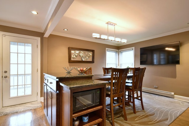 dining room featuring light wood finished floors, a baseboard heating unit, and ornamental molding