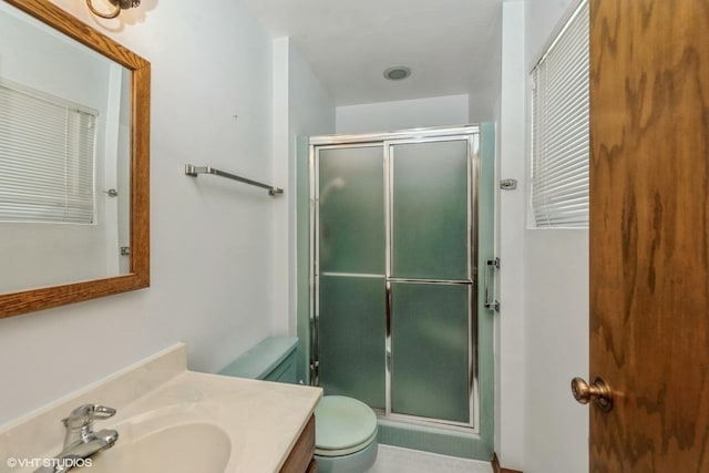 bathroom with toilet, a shower with door, and vanity