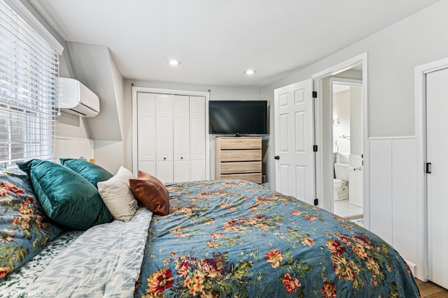 bedroom featuring ensuite bathroom, recessed lighting, a wainscoted wall, a wall mounted AC, and a closet