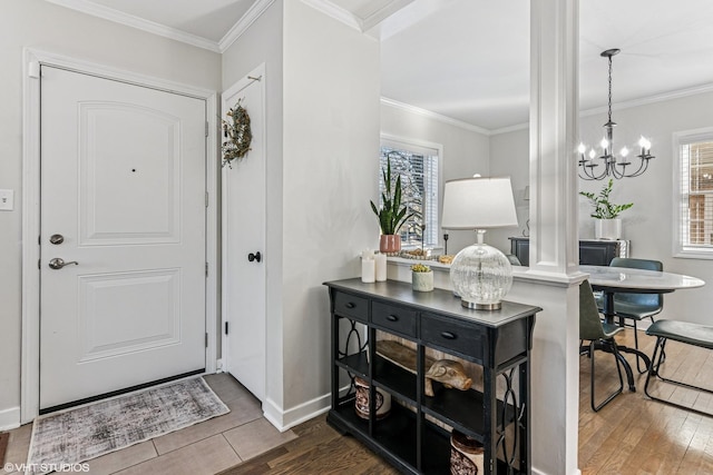 entrance foyer with a healthy amount of sunlight, a chandelier, wood finished floors, and ornamental molding