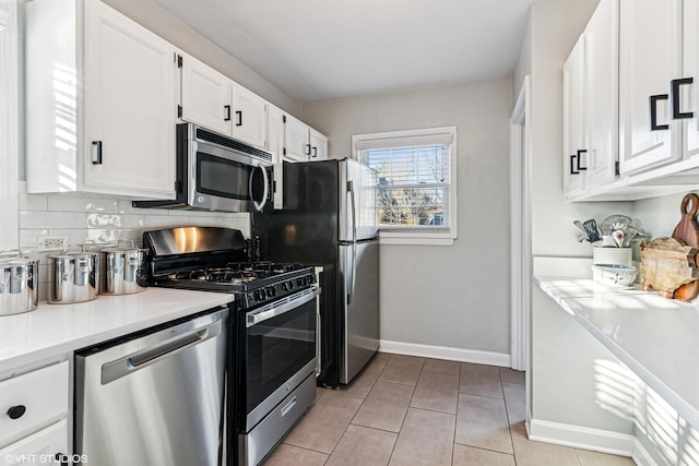 kitchen featuring light tile patterned floors, white cabinets, decorative backsplash, stainless steel appliances, and light countertops