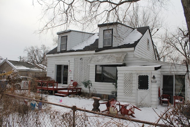 snow covered property with a deck