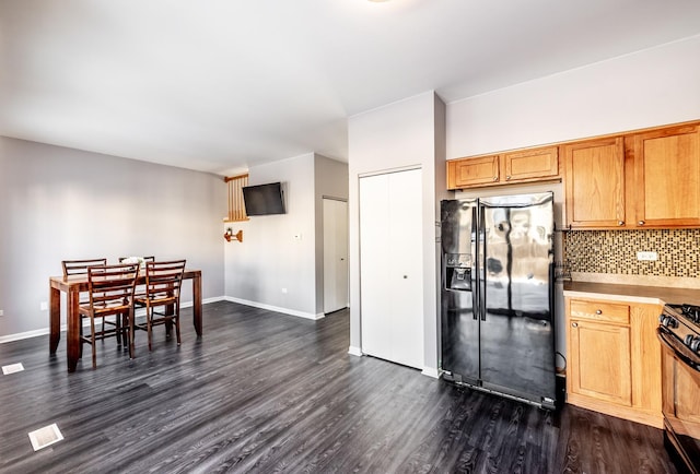 kitchen with dark wood-style flooring, light countertops, backsplash, brown cabinets, and black appliances