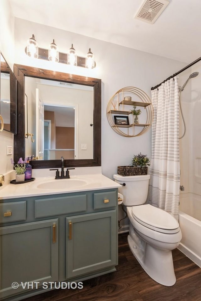 full bath with visible vents, toilet, wood finished floors, shower / bath combination with curtain, and vanity