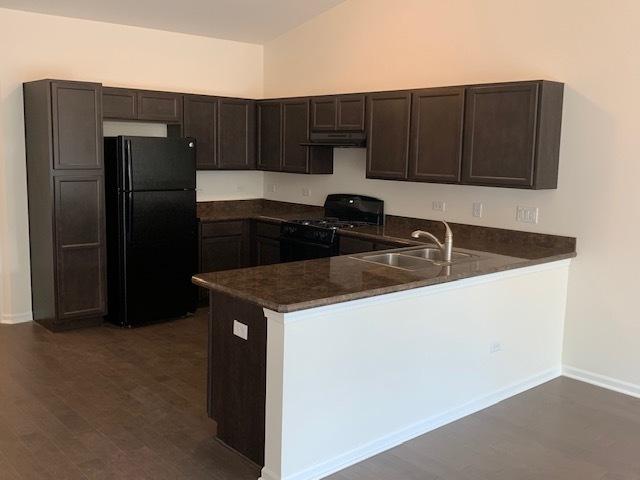 486 Ridge Ln, Bolingbrook, IL 60440 - kitchen featuring sink, dark brown cabinetry, black appliances, dark hardwood / wood-style flooring, and kitchen peninsula