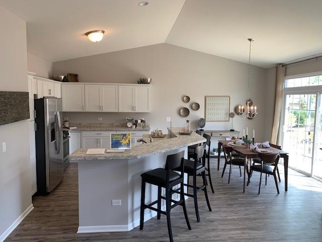 486 Ridge Ln, Bolingbrook, IL 60440 - kitchen featuring pendant lighting, white cabinetry, stainless steel fridge, a chandelier, and kitchen peninsula