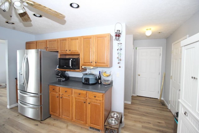 kitchen with ceiling fan, light hardwood / wood-style floors, a textured ceiling, and stainless steel fridge