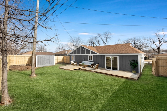 back of property with a wooden deck, an outdoor living space, a storage shed, and a yard