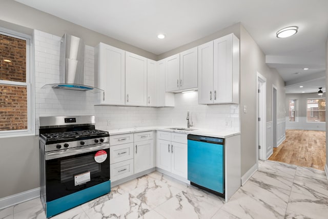 kitchen with dishwashing machine, wall chimney range hood, sink, stainless steel gas range oven, and white cabinets