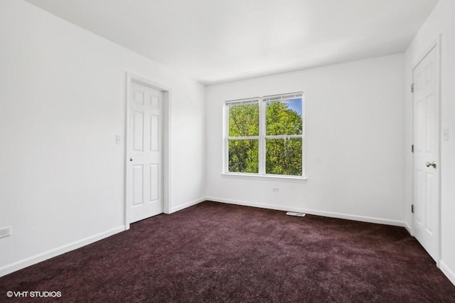 unfurnished bedroom with dark colored carpet