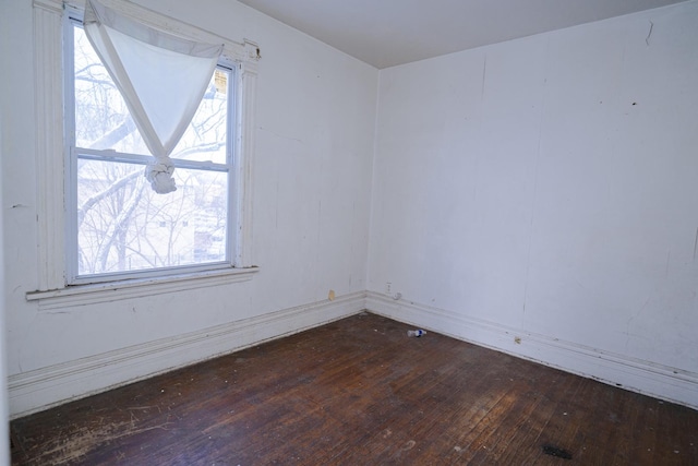 empty room featuring dark hardwood / wood-style flooring and a wealth of natural light