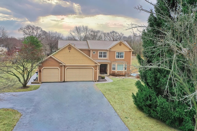 view of front of house featuring aphalt driveway, a front yard, and an attached garage