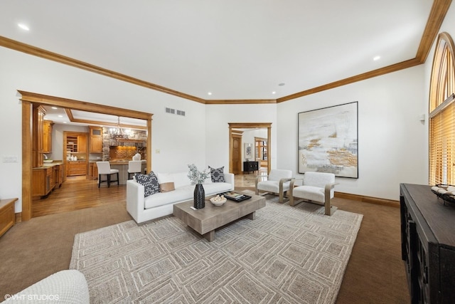 carpeted living room featuring crown molding and a notable chandelier