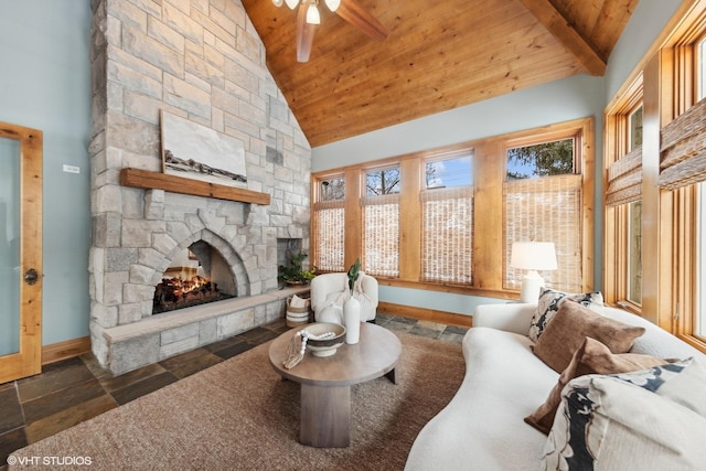 living room with beam ceiling, a stone fireplace, wooden ceiling, and high vaulted ceiling