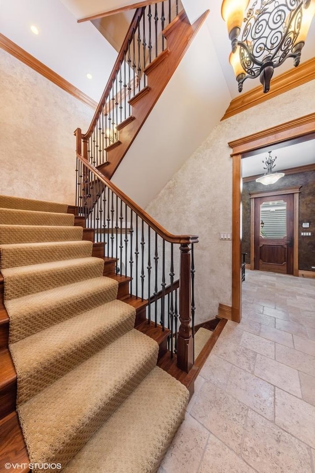 staircase with crown molding and a high ceiling