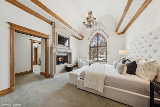 carpeted bedroom with high vaulted ceiling, a notable chandelier, and a fireplace