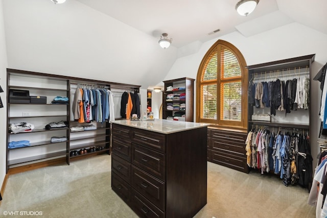 spacious closet featuring lofted ceiling and light carpet