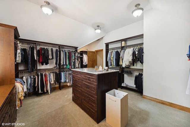 walk in closet with lofted ceiling and light carpet