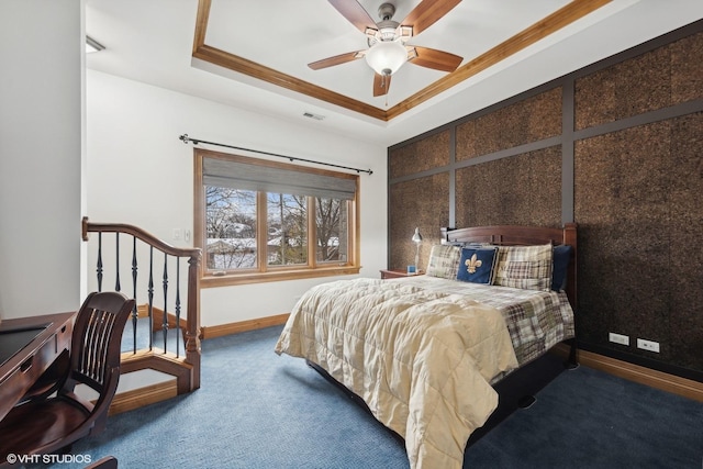 carpeted bedroom with ornamental molding and a tray ceiling