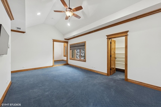 spare room with dark carpet, vaulted ceiling, and ceiling fan