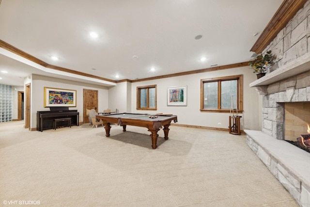 game room with ornamental molding, a stone fireplace, light carpet, and billiards