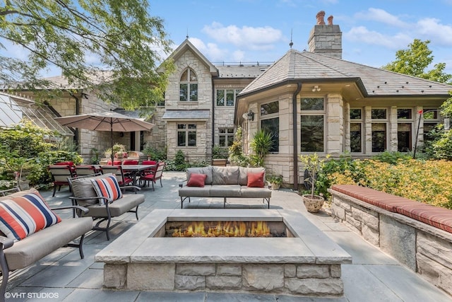 5101 Central Ave, Western Springs, IL 60558 - rear view of property featuring an outdoor living space with a fire pit, stone siding, a patio, and a high end roof