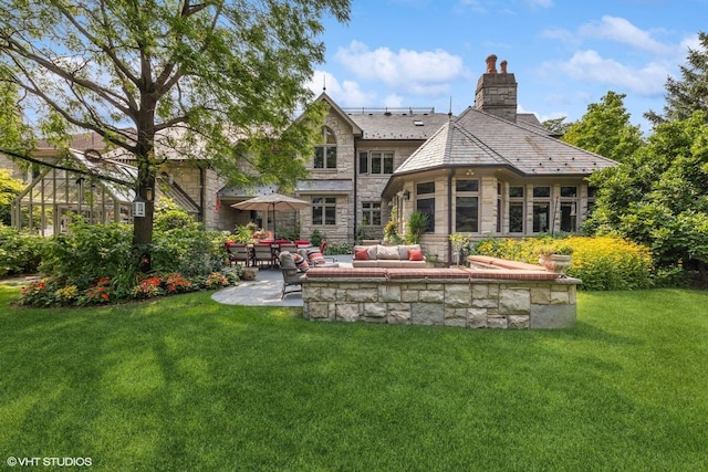 5101 Central Ave, Western Springs, IL 60558 - rear view of house featuring stone siding, a yard, a patio, and a chimney