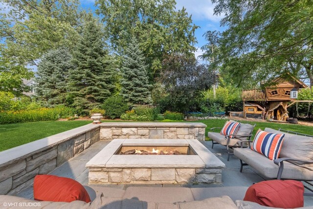 view of patio with an outdoor living space with a fire pit